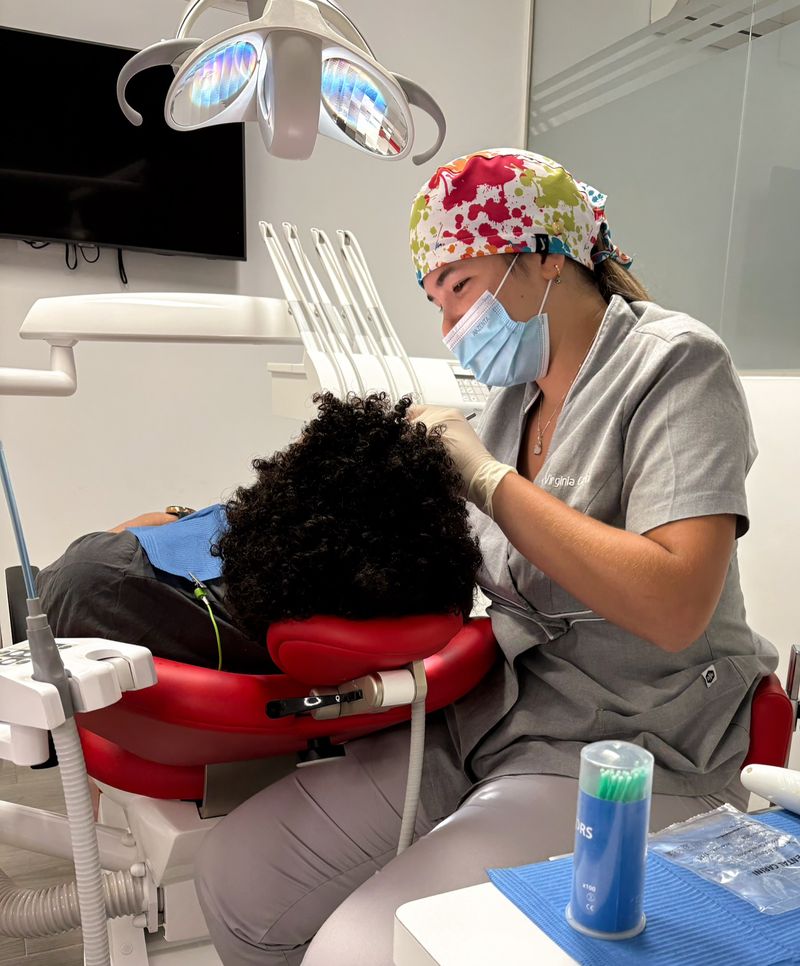Odontología estética: profesional trabajando con un paciente en el sillón dental