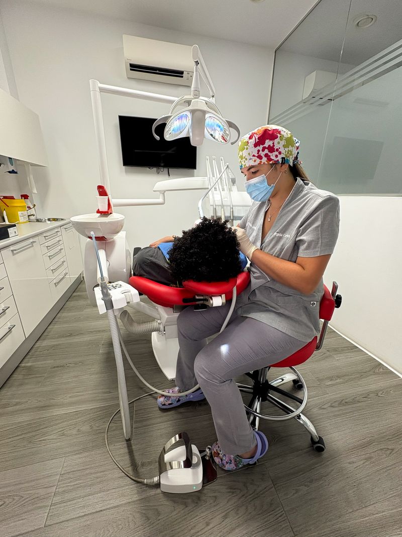Odontopediatría: profesional atendiendo a un paciente en el sillón dental