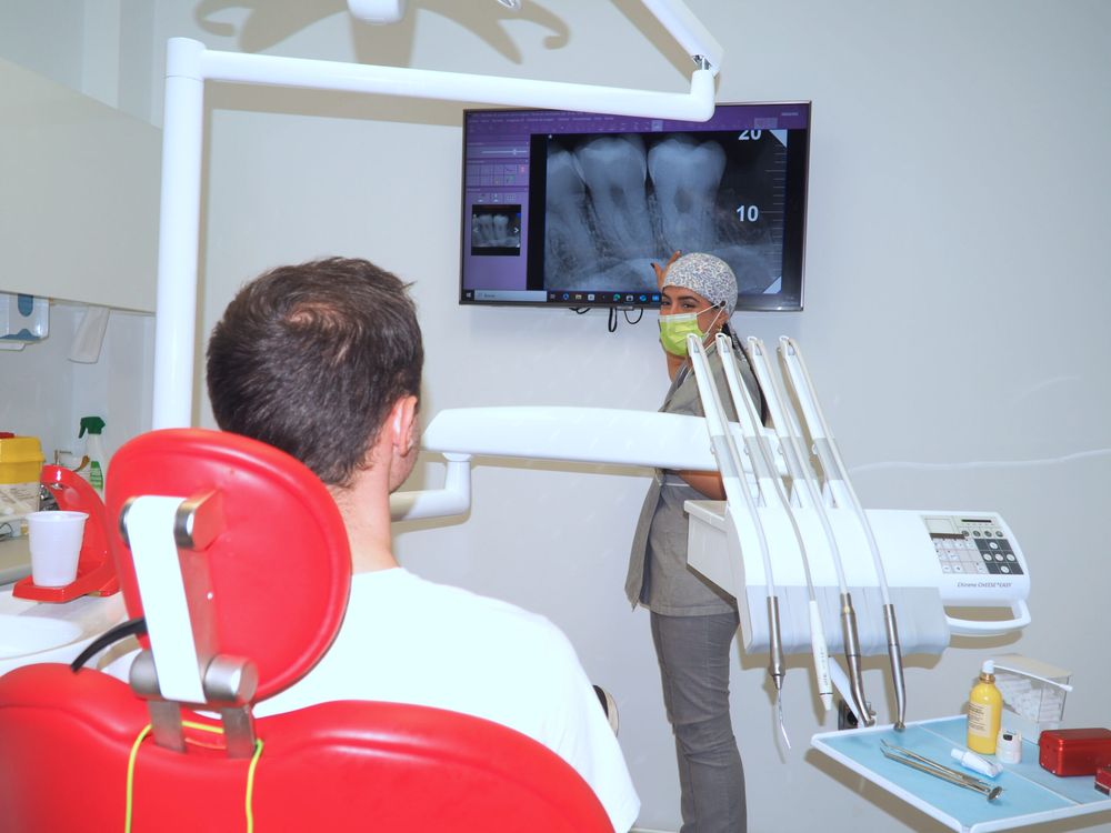 Paciente en el sillón dental mirando una radiografía en el monitor
